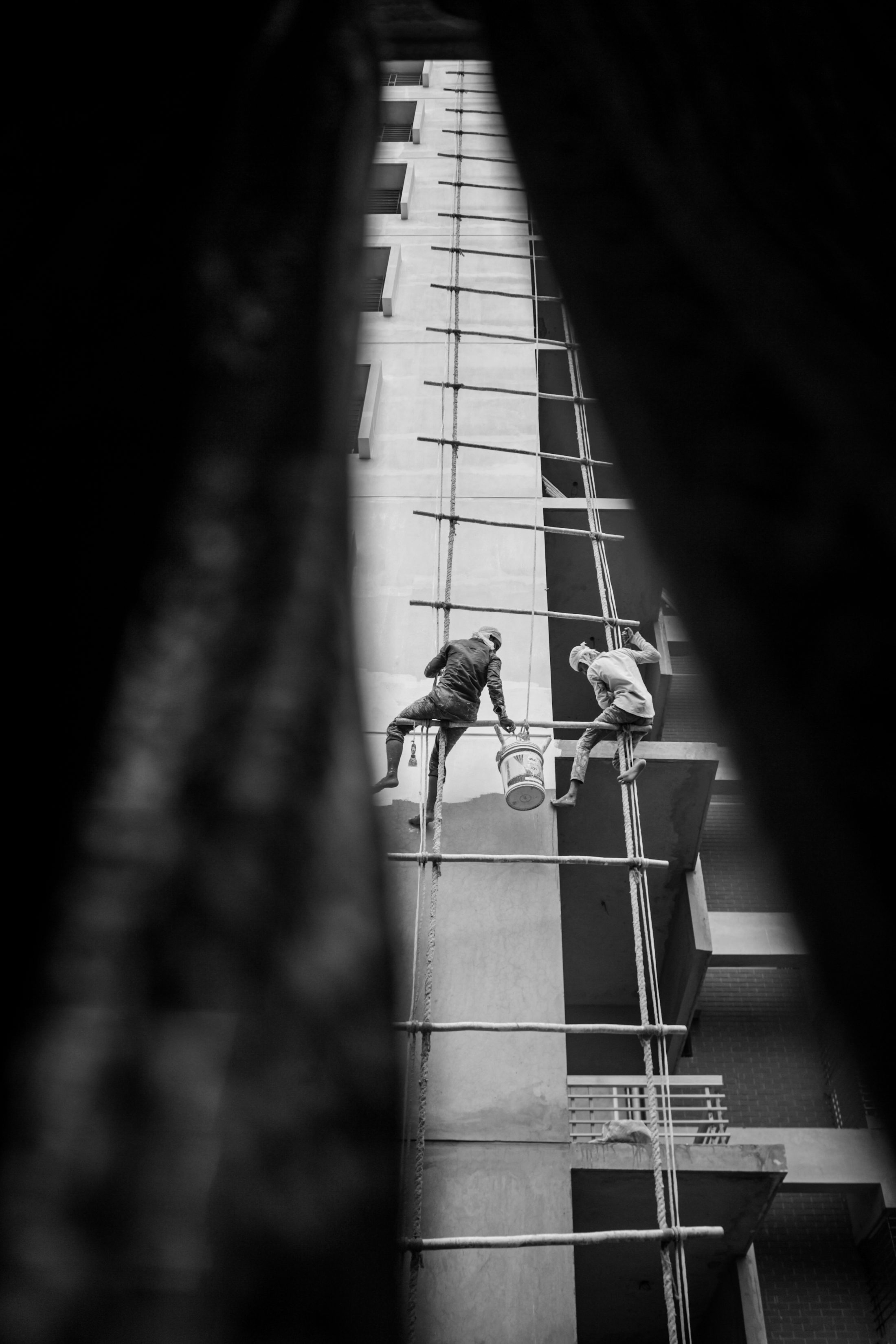 Bangladeshi workers painting and working on a building facade