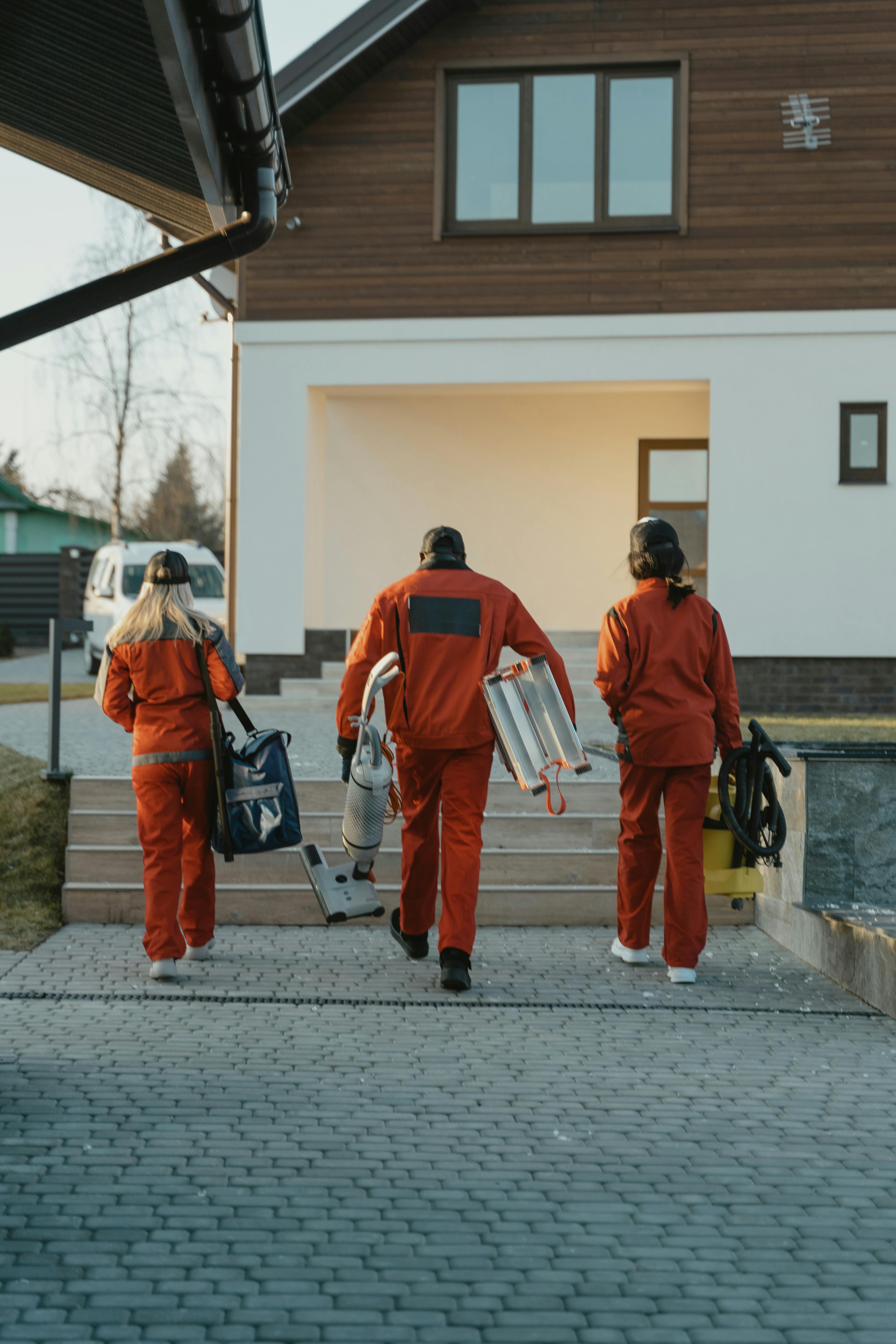 Home service workers walking toward a house to begin a job