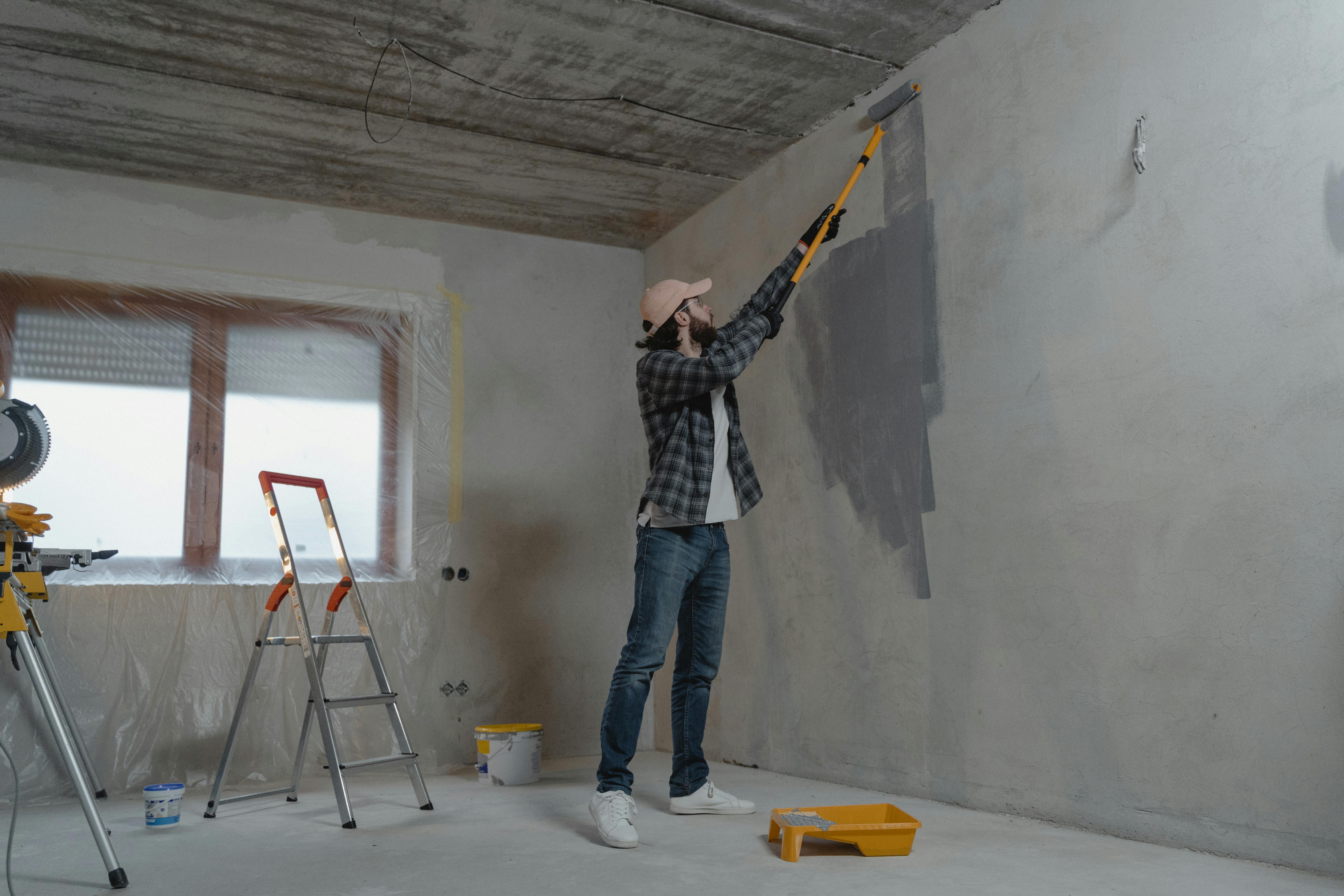 Professional painter rolling a fresh coat onto an interior wall